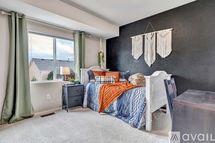 A bedroom with a bed, chair, and window.