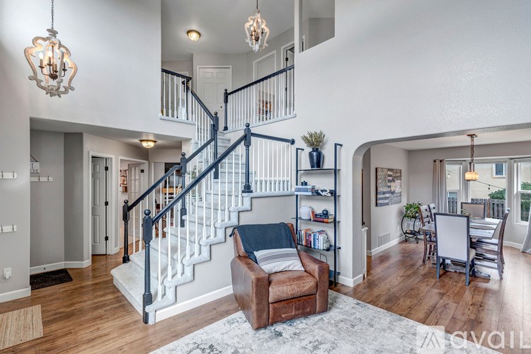 A living room with a couch and a staircase.