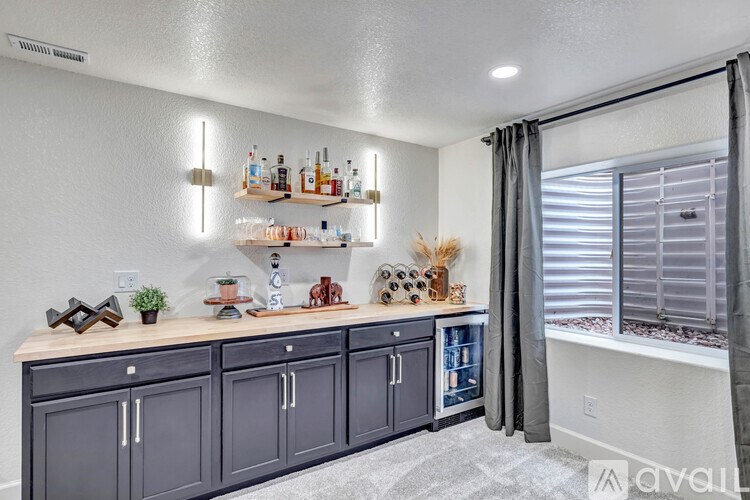 A kitchen with a bar area and a window with blinds.