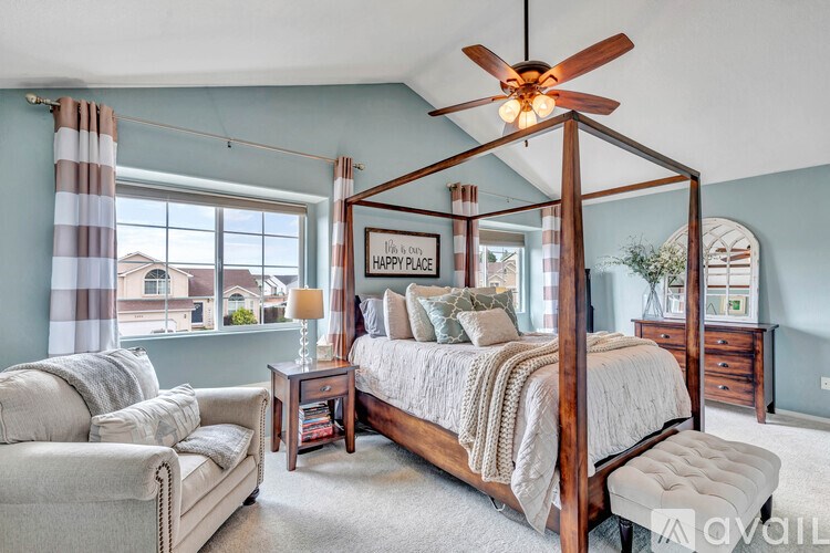 A bedroom with a four poster bed and a couch.