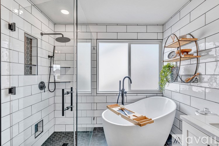 A white bathroom with a black shower head and a white bathtub.