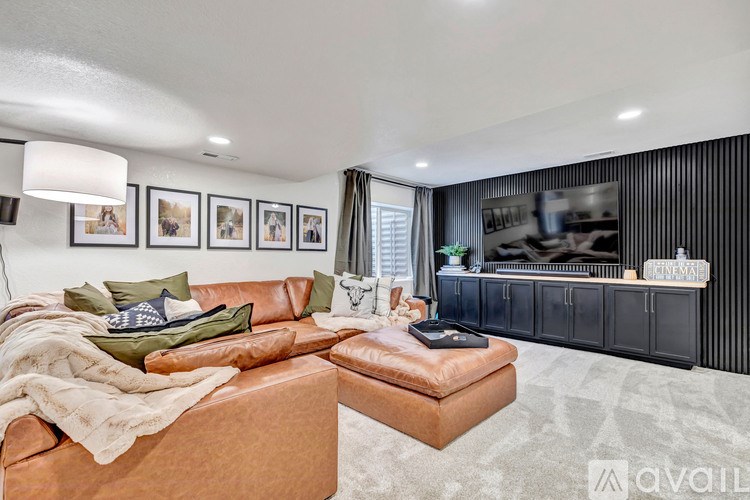 A living room with a brown leather couch and a television.