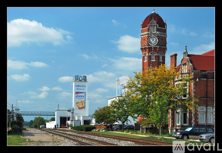 A train station with a clock tower and a Jiffy Lube sign.