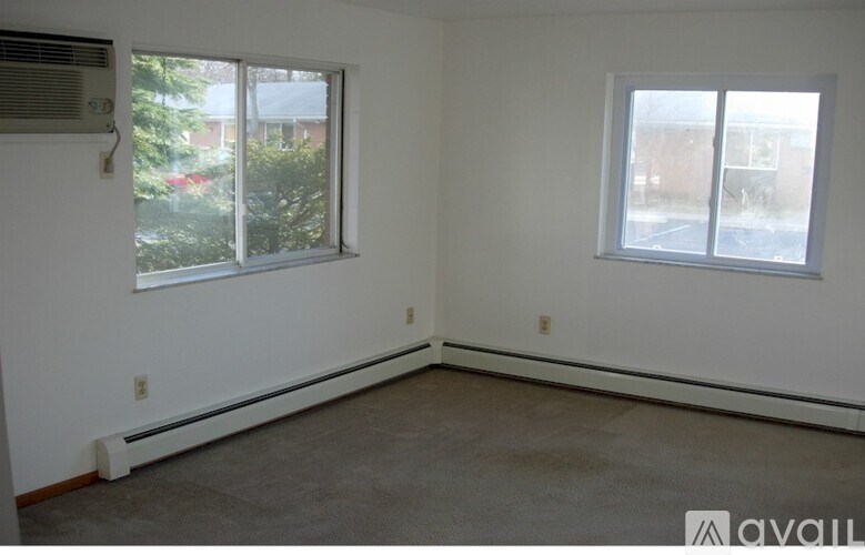 A room with a window and a wall heater.