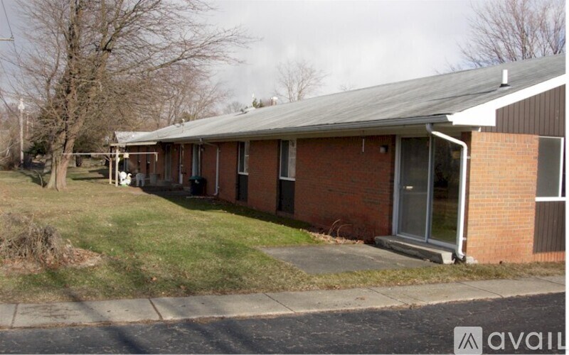 A brick house with a metal roof and a white door.