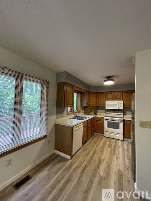 A kitchen with wooden cabinets and a white refrigerator.
