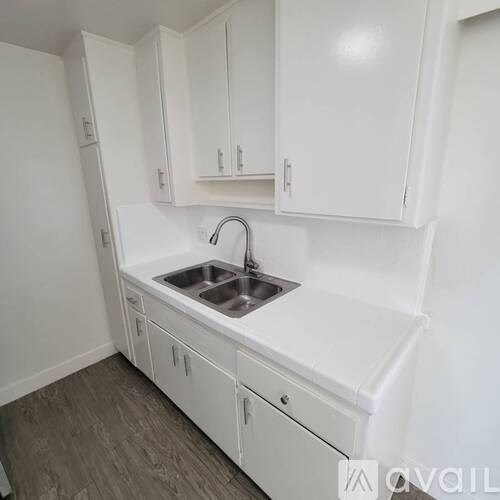 A white kitchen with a sink and cabinets.