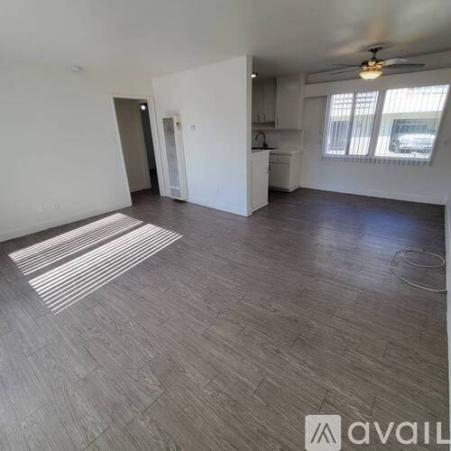 A spacious room with a striped rug on the floor.