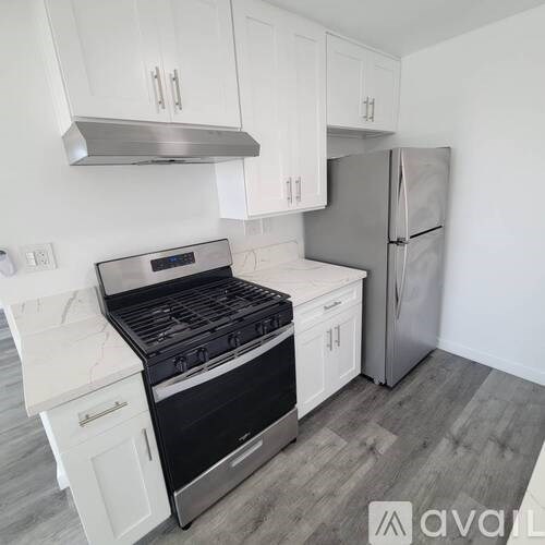 A kitchen with a stove, refrigerator, and cabinets.
