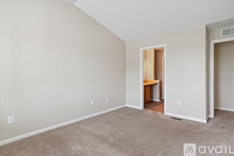 A room with a carpeted floor and a doorway leading to another room.