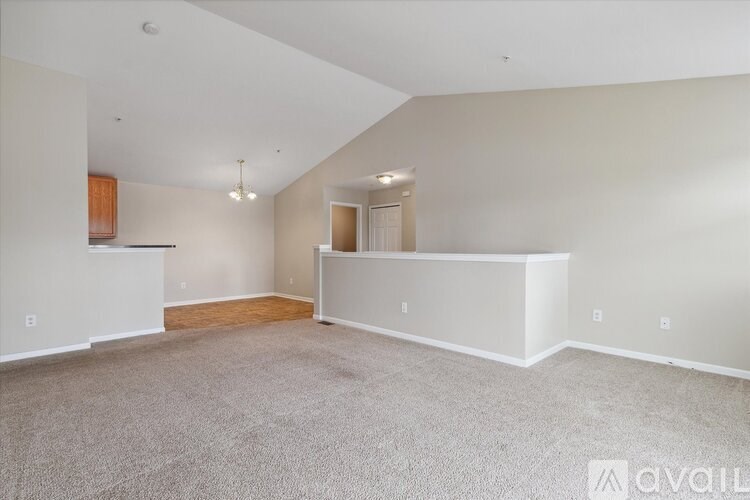 A spacious room with a carpeted floor and white walls.