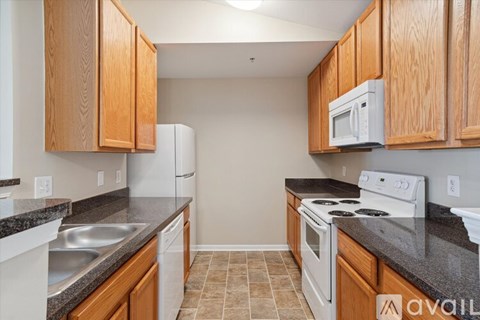 A kitchen with wooden cabinets and a white fridge.