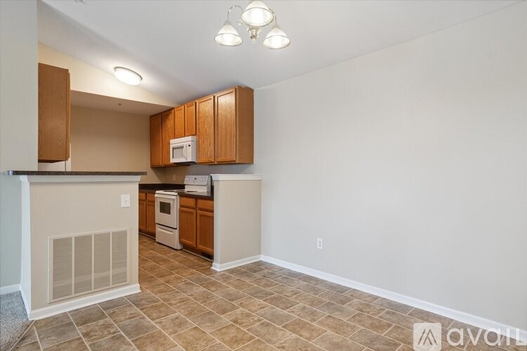 A kitchen with wooden cabinets and a tiled floor.