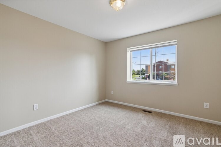 A room with a window showing a view of a building outside.