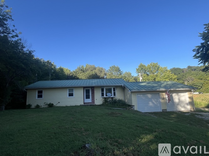 A house with a flag on the garage door is for sale.