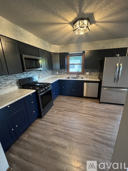 A kitchen with dark cabinets and a wooden floor.