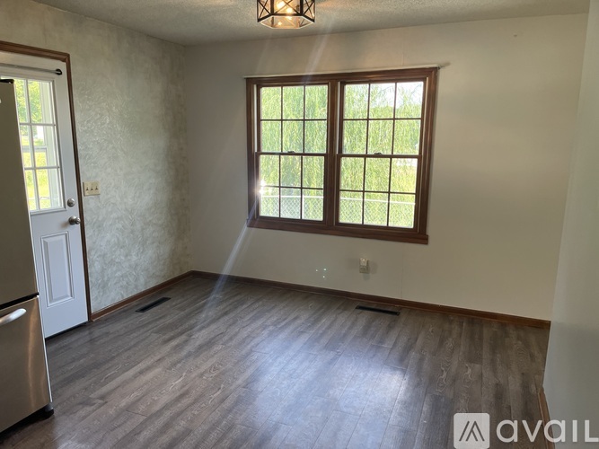 A room with a window and wooden flooring is available for rent.