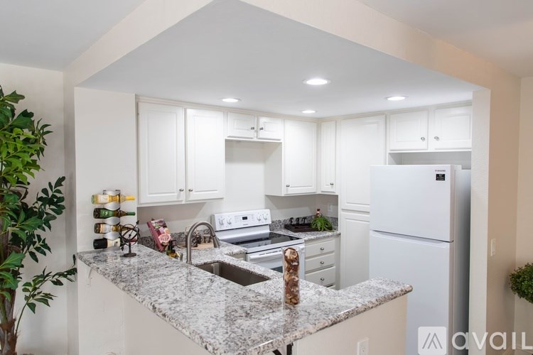 A kitchen with white cabinets and a marble countertop.