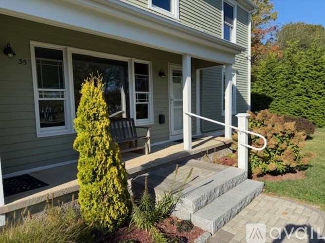 A house with a grey siding and a white door.