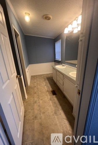 A bathroom with a sink, mirror, and tiled floor.