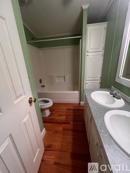 A bathroom with a toilet, sink, and mirror.