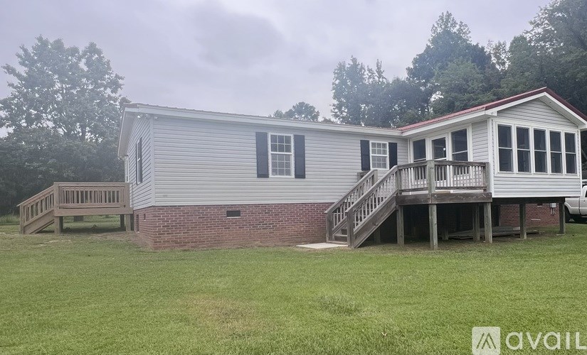 A house with a grey roof and a deck is available for sale.