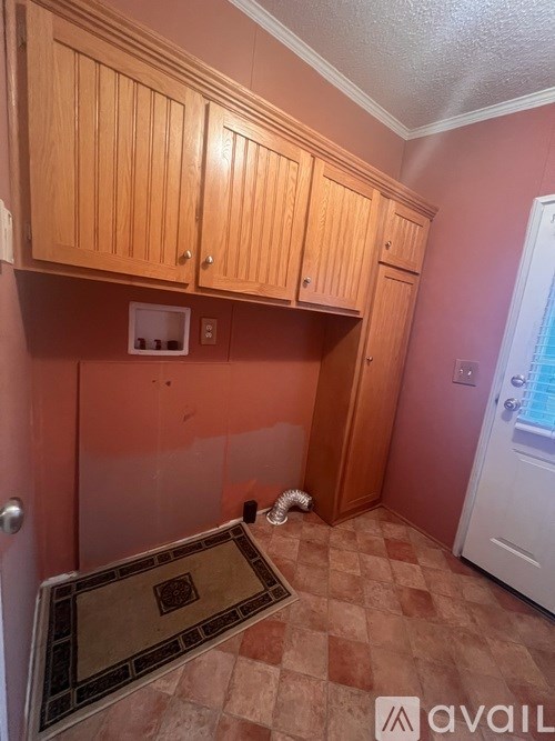 A kitchen with wooden cabinets and a checkered floor.