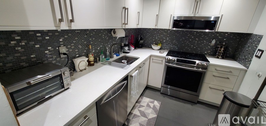 A kitchen with white cabinets and a black and white checkered floor.
