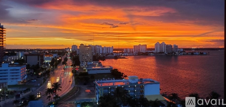 A view of a city from a high vantage point with buildings and a body of water.
