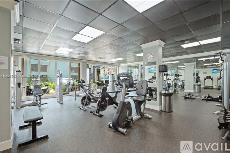 A gym with a variety of equipment including treadmills, stationary bikes, and weight machines.