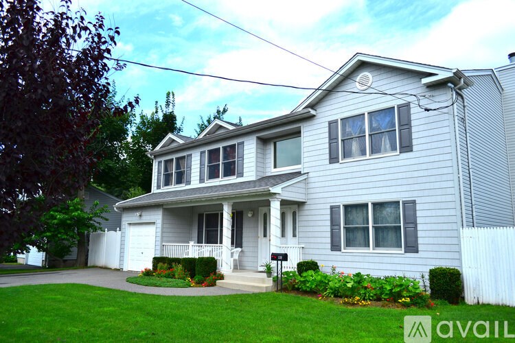 A two-story house with a front porch and a white picket fence.