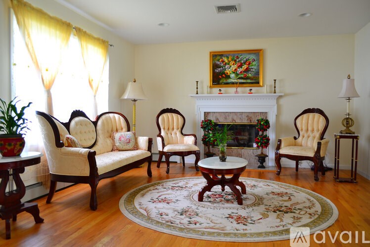 A living room with a fireplace and a painting above it.
