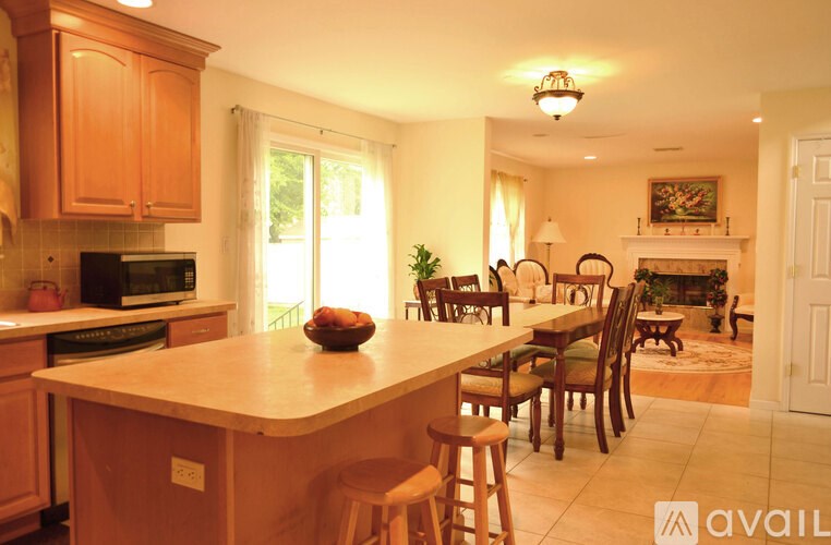 A kitchen with wooden cabinets and a large island with bar stools.