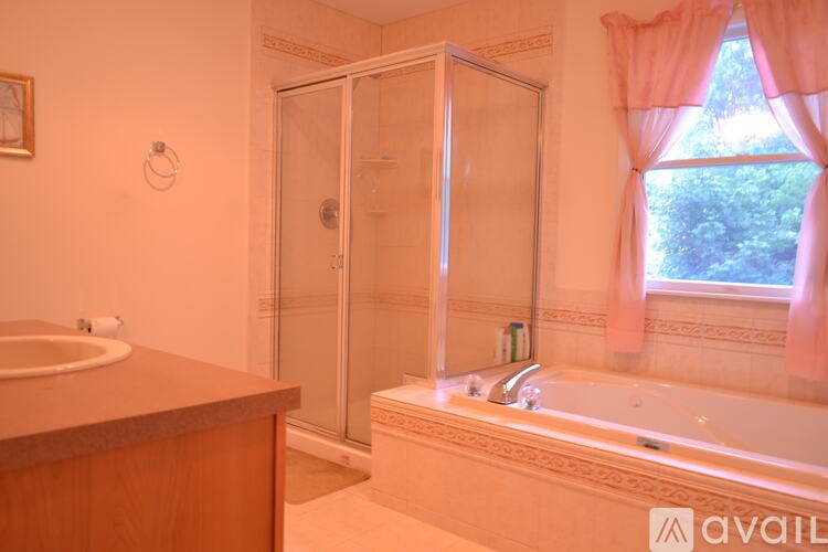 A bathroom with a tub, sink, and shower.