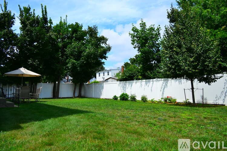 A backyard with a white fence and a gazebo.