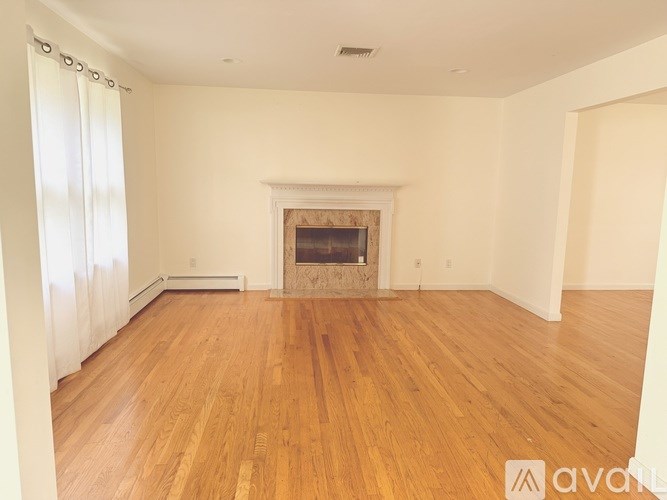 A room with a fireplace and wooden floors.