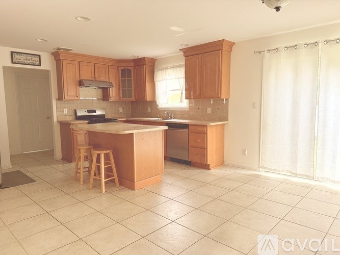A kitchen with wooden cabinets and a tile floor.