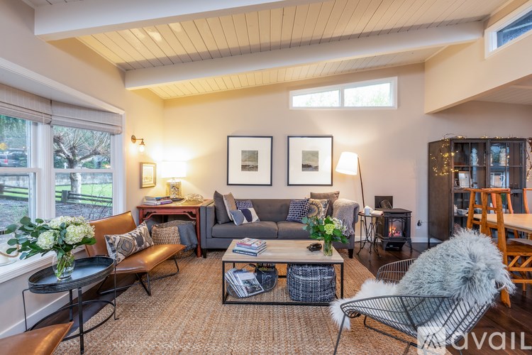 A living room with a grey couch, a black coffee table, and a grey chair.