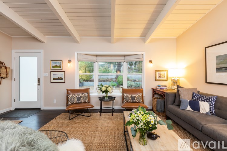 A living room with a grey couch, a coffee table, and a rug.