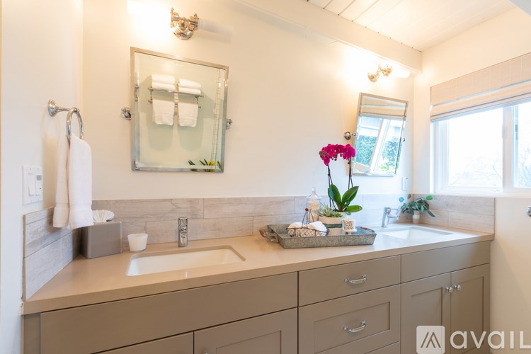 A bathroom with a sink, mirror, and a window.