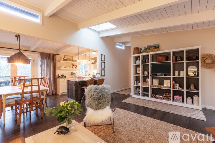 A cat is sitting on a chair in a room with a table in front of it.