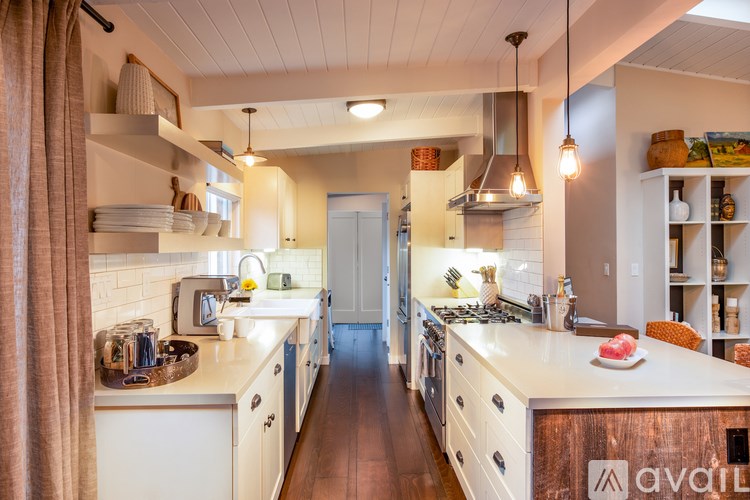 A kitchen with white cabinets and a wooden island.