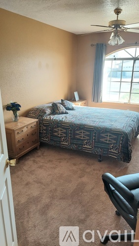 A bedroom with a bed, nightstand, and lamp.