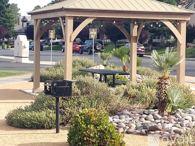 A gazebo with a mailbox in front of it.