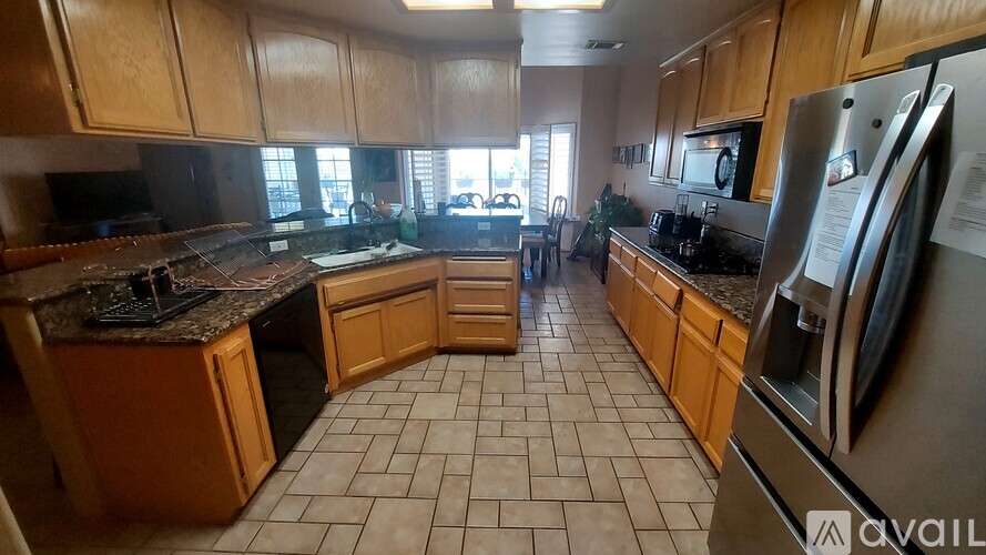 A kitchen with wooden cabinets and tile flooring.