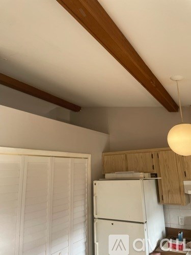 A kitchen with a white fridge and wooden cabinets.