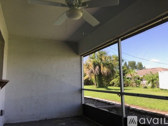 A room with a ceiling fan and sliding glass doors.