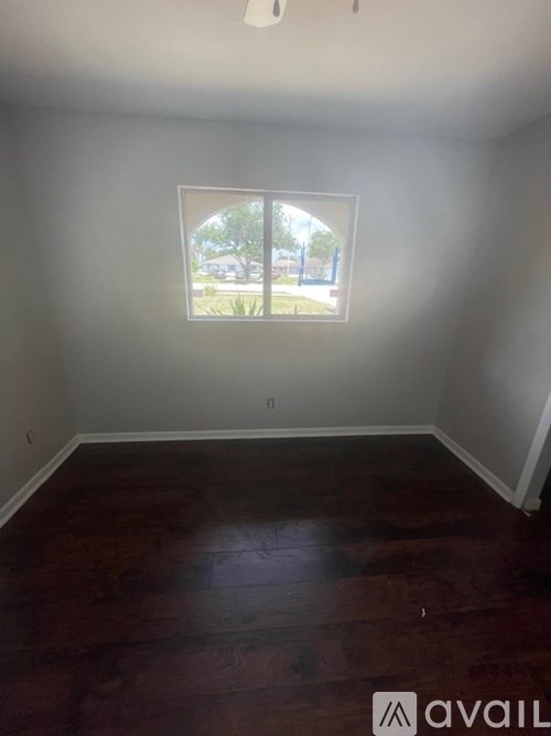 A room with a window and wooden floors.