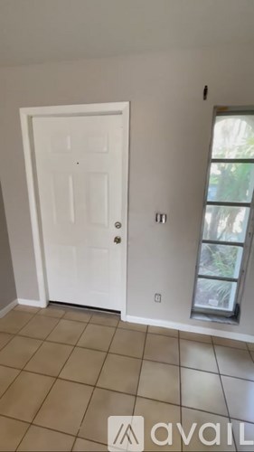 A white door is in a room with tiled flooring.