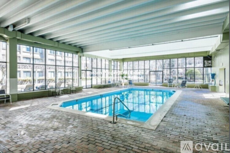 A large indoor swimming pool with a glass wall on one side.